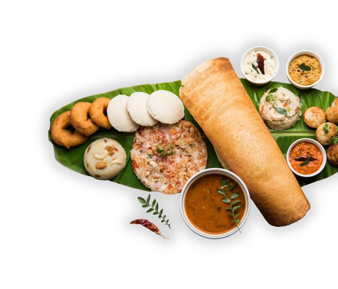 Idli, vada, dosa, upma and chutneys on a banana leaf